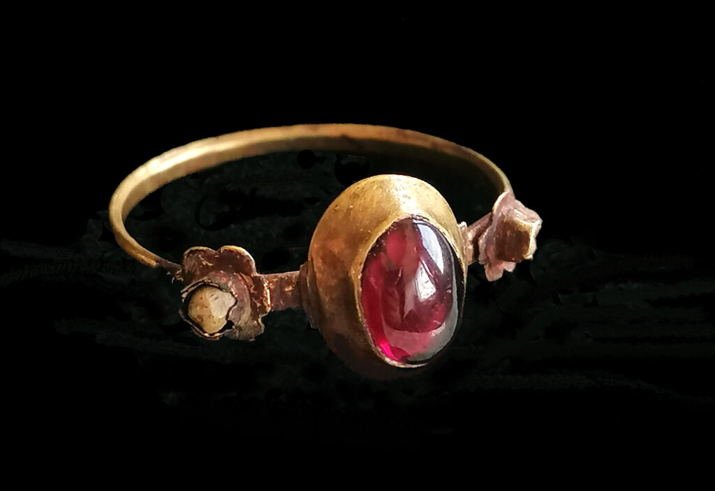 Ring aus Berlin-Mitte, Goldfingerring mit Böhmischem Granat und floral eingefassten Nebensteinen aus Brunnenverfüllung (13./14. Jh.)